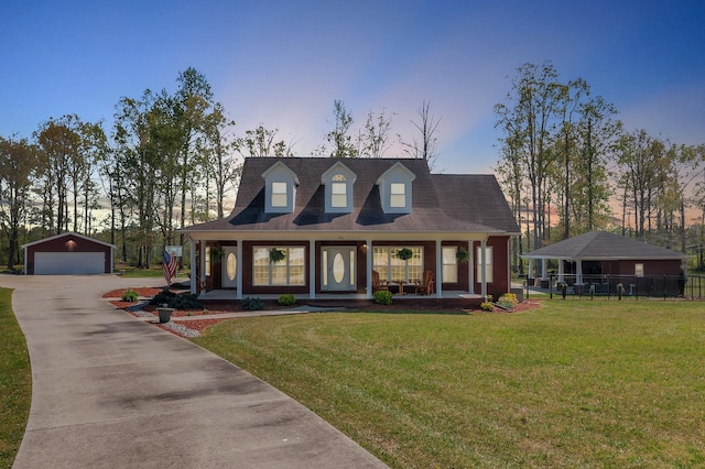 view of front facade featuring a garage, a porch, an outbuilding, and a lawn