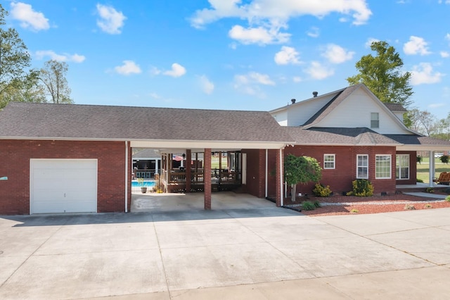 view of front of house with driveway, roof with shingles, an attached garage, and brick siding