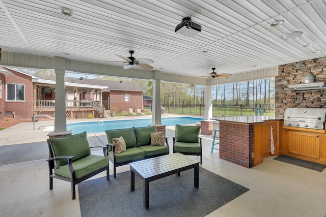 view of patio / terrace featuring an outdoor hangout area, ceiling fan, an outdoor kitchen, fence, and a grill