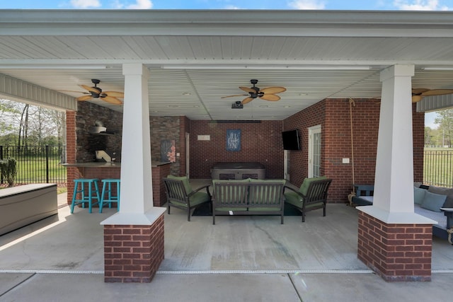 view of patio / terrace with fence, a bar, ceiling fan, and outdoor lounge area