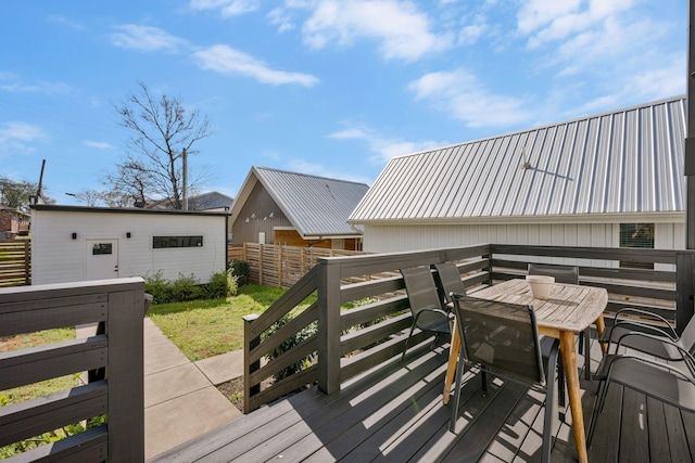 wooden deck featuring outdoor dining area and an outbuilding