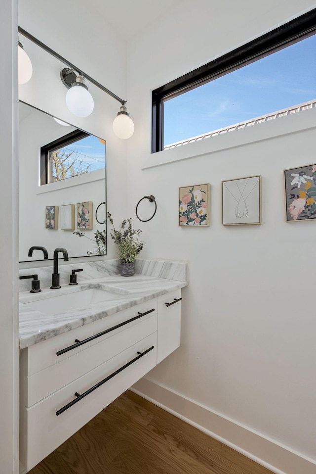 bathroom featuring wood finished floors, vanity, and baseboards