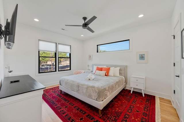 bedroom featuring multiple windows, light wood-style floors, recessed lighting, baseboards, and a ceiling fan