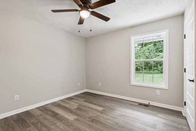 1212 Hollis Ln, Lafayette, TN 37083 - unfurnished room featuring ceiling fan, baseboards, wood finished floors, and visible vents