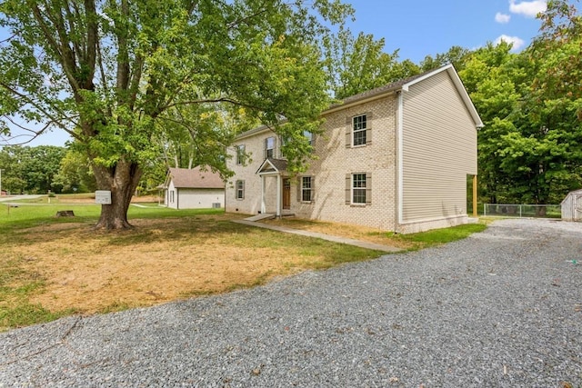 1212 Hollis Ln, Lafayette, TN 37083 - view of front of property with driveway, brick siding, a front yard, and an outbuilding