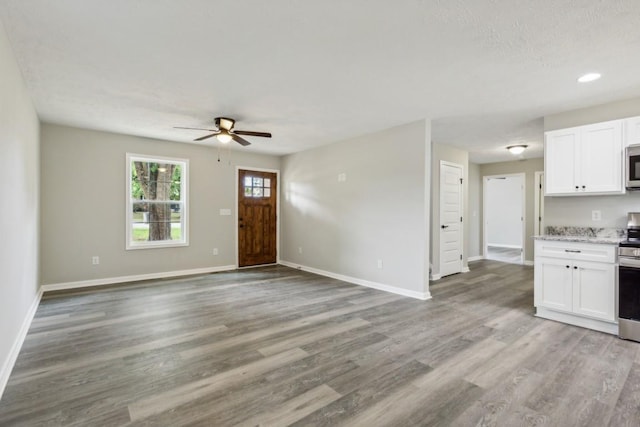 1212 Hollis Ln, Lafayette, TN 37083 - unfurnished living room featuring ceiling fan, baseboards, light wood-style floors, and recessed lighting