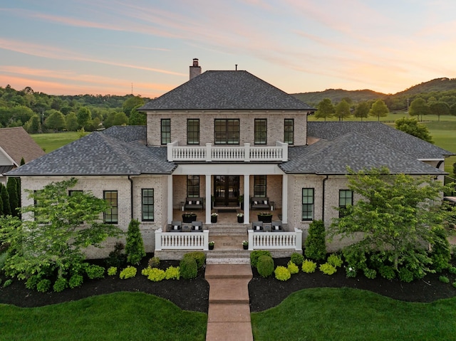 6302 Wild Heron Way, College Grove, TN 37046 - view of front of home featuring a balcony, a chimney, brick siding, a shingled roof, and a patio area
