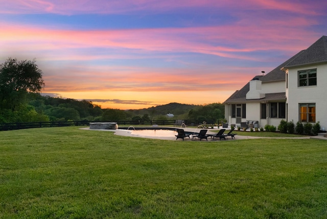 yard at dusk with an outdoor fire pit, a patio, and fence