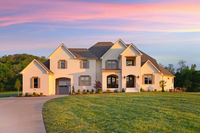 traditional-style house featuring a front yard, stucco siding, and driveway