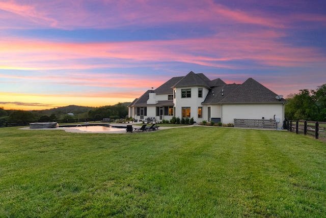 view of front of house featuring a patio, stucco siding, fence, and a front yard