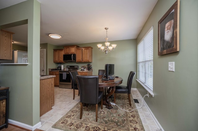 dining space with baseboards and a notable chandelier