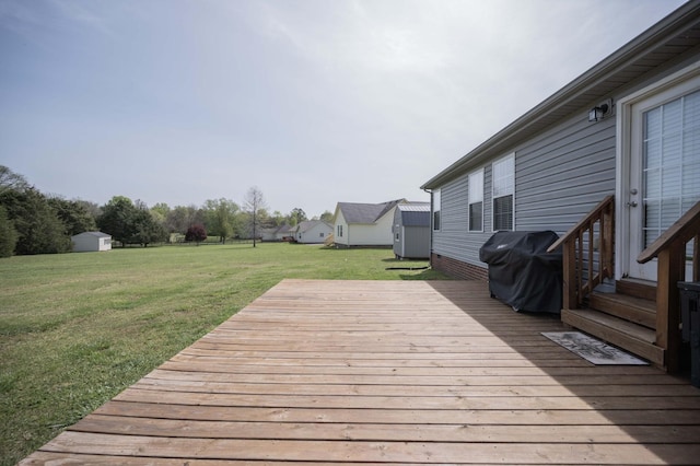 wooden deck with grilling area, a lawn, a storage unit, and an outdoor structure