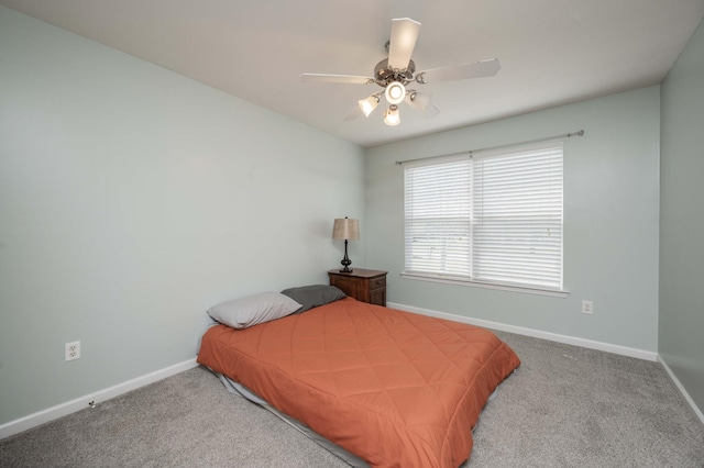 carpeted bedroom with ceiling fan and baseboards