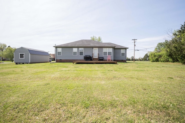 rear view of house featuring a yard, an outdoor structure, crawl space, and a deck