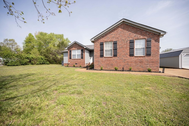ranch-style home with an outdoor structure, a front lawn, and brick siding