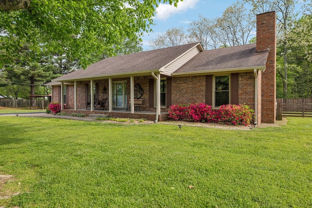 ranch-style house featuring a front lawn, a porch, a chimney, and fence