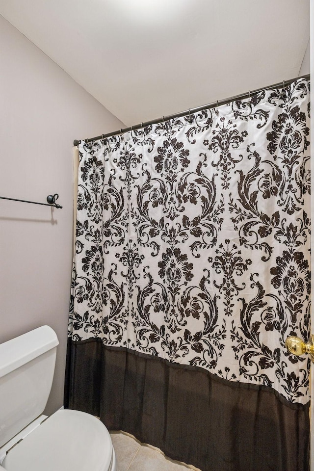 bathroom with curtained shower and toilet