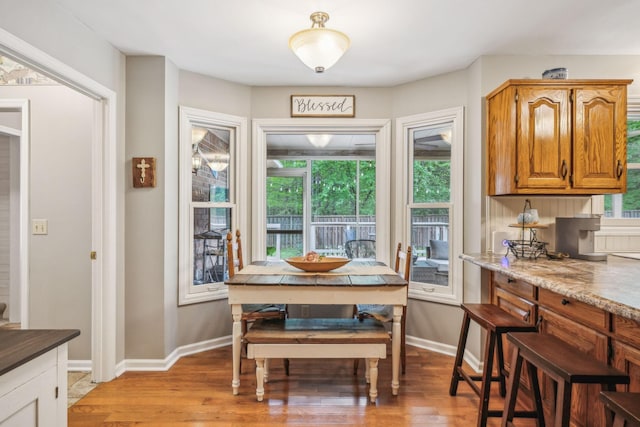 dining area with baseboards and light wood-style floors
