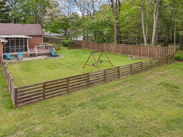 view of yard with a wooden deck, a sunroom, and a fenced backyard