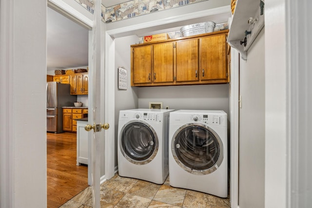 clothes washing area with cabinet space and independent washer and dryer