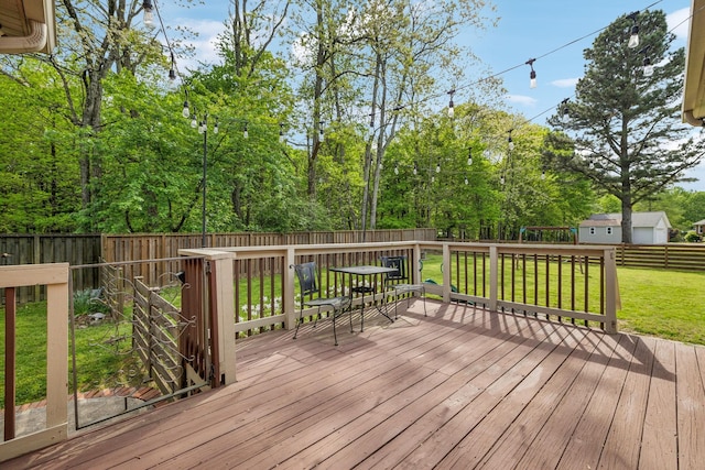 deck featuring a fenced backyard, outdoor dining area, and a yard