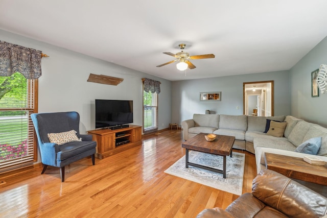 living area with light wood finished floors, baseboards, and ceiling fan