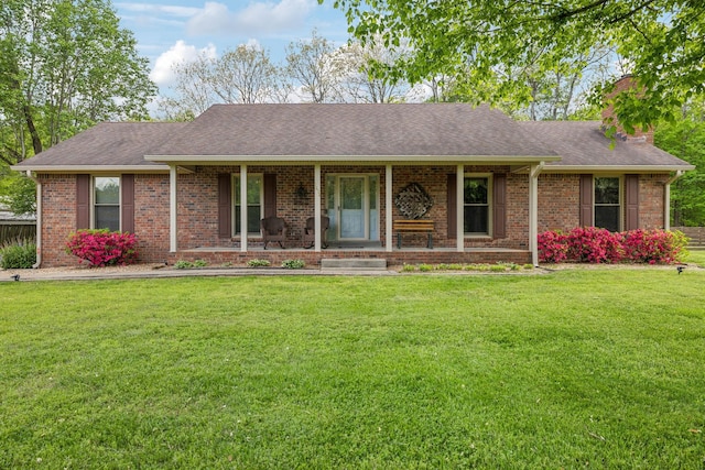ranch-style home with brick siding, covered porch, and a front yard