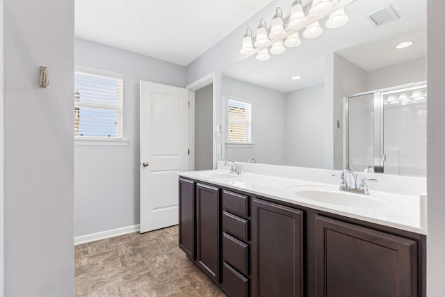 bathroom with baseboards, a sink, visible vents, and a stall shower