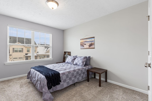 carpeted bedroom with a textured ceiling and baseboards