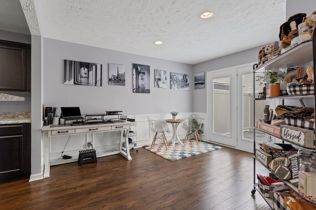 interior space with wainscoting, a textured ceiling, dark wood-style floors, and recessed lighting