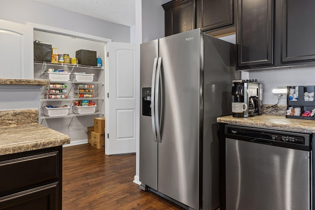 kitchen with dark brown cabinetry, appliances with stainless steel finishes, dark wood-type flooring, and light countertops