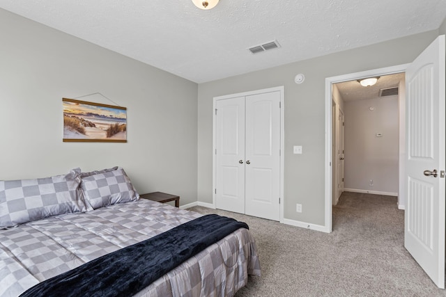 carpeted bedroom with a textured ceiling, baseboards, visible vents, and a closet