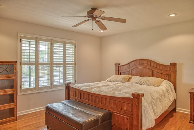 bedroom with light wood-style floors, baseboards, and ceiling fan