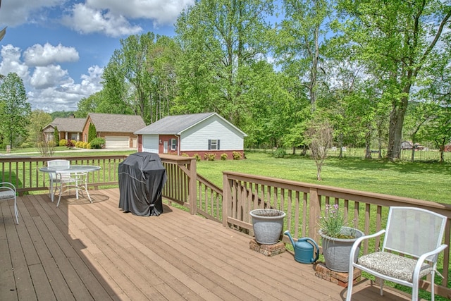 deck with a lawn, an outdoor structure, and area for grilling