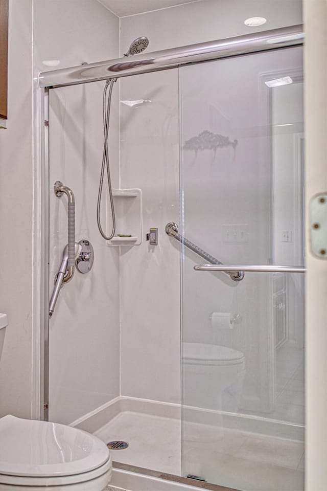 full bath featuring toilet and a stall shower