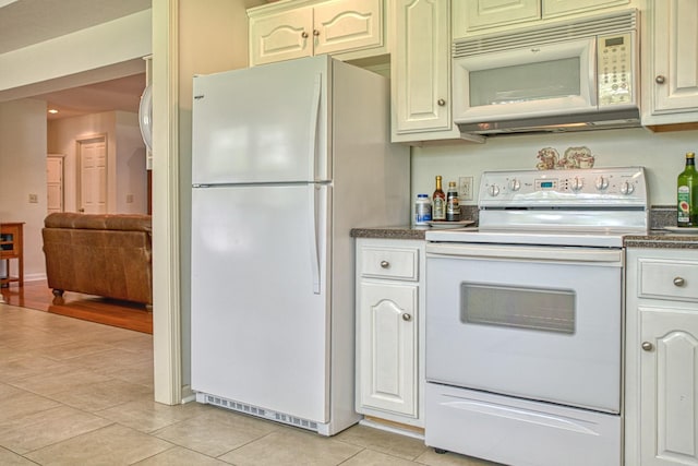 kitchen with dark countertops, white appliances, and light tile patterned floors