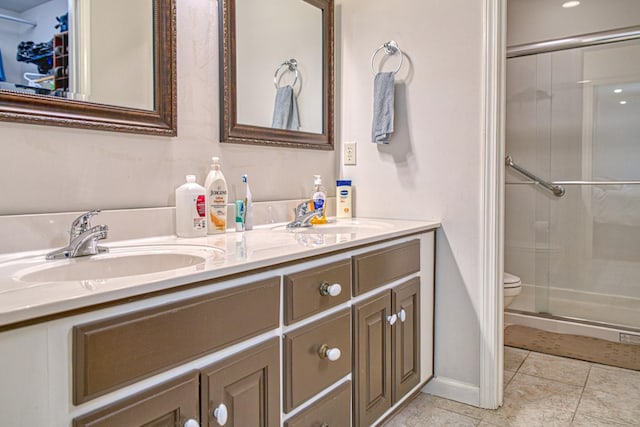 bathroom with tile patterned floors, a sink, double vanity, and a stall shower