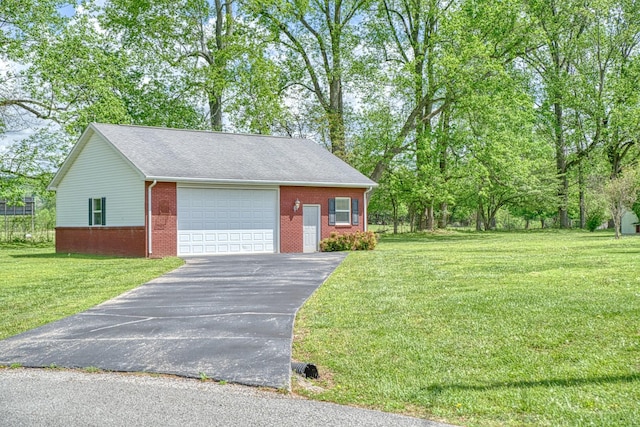 view of front of home featuring aphalt driveway, brick siding, a front yard, and a garage