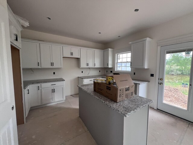 kitchen featuring white cabinets, stone countertops, and a center island