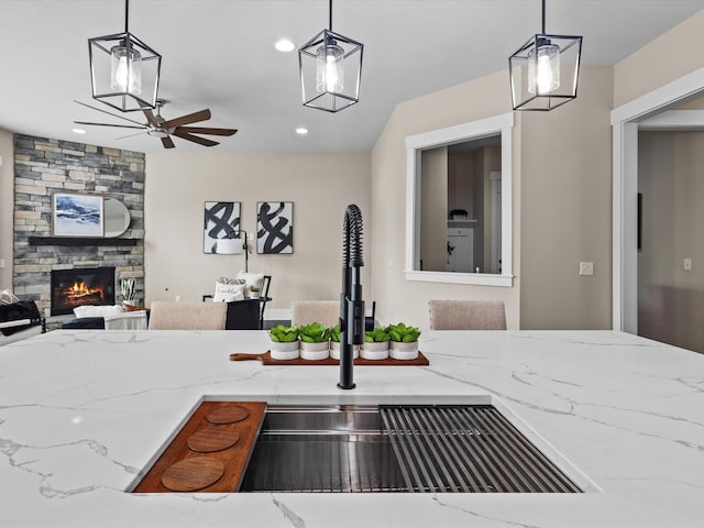 1068 Amelia Park Dr, Franklin, TN 37067 - kitchen with light stone countertops, a sink, a fireplace, and ceiling fan