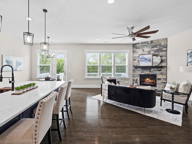1068 Amelia Park Dr, Franklin, TN 37067 - living room with ceiling fan with notable chandelier, a fireplace, dark wood finished floors, baseboards, and recessed lighting