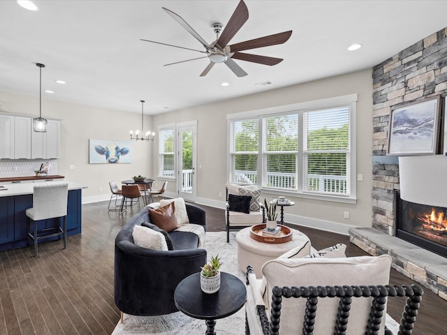 1068 Amelia Park Dr, Franklin, TN 37067 - living area with dark wood finished floors, a stone fireplace, visible vents, and ceiling fan with notable chandelier