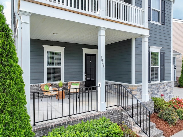 1068 Amelia Park Dr, Franklin, TN 37067 - view of exterior entry with stone siding, covered porch, and a balcony