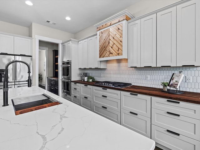 1068 Amelia Park Dr, Franklin, TN 37067 - kitchen with a sink, visible vents, decorative backsplash, wooden counters, and appliances with stainless steel finishes