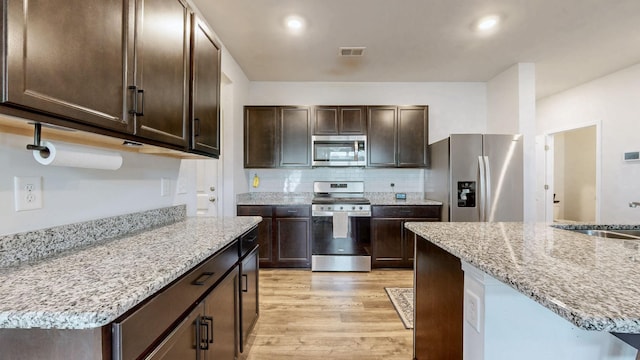 615 Pine Bloom Rd, Lebanon, TN 37087 - kitchen featuring a sink, light wood-type flooring, dark brown cabinetry, appliances with stainless steel finishes, and visible vents