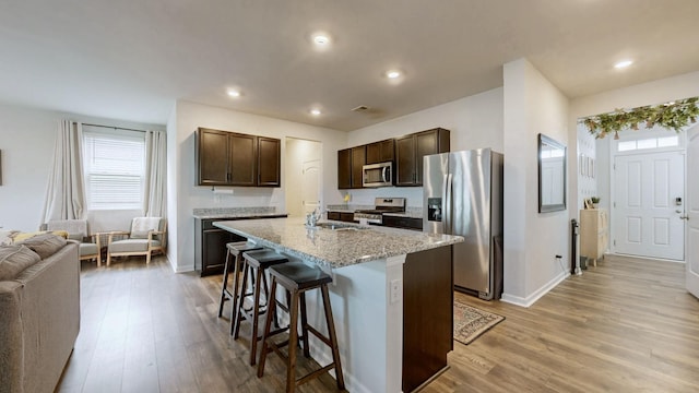 615 Pine Bloom Rd, Lebanon, TN 37087 - kitchen featuring stainless steel appliances, dark brown cabinets, baseboards, light wood-style floors, and a breakfast bar area