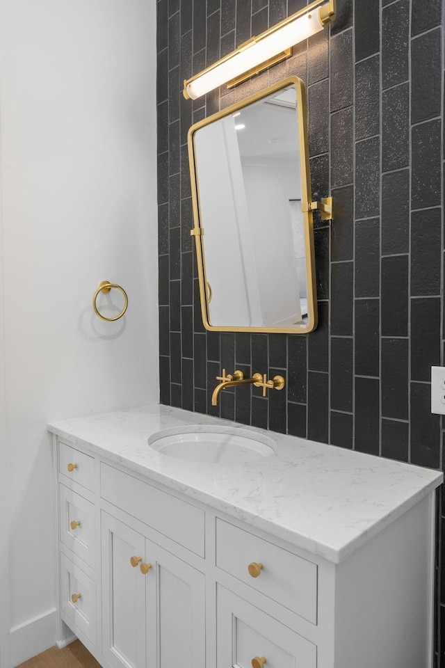 bathroom featuring tile walls, decorative backsplash, and vanity