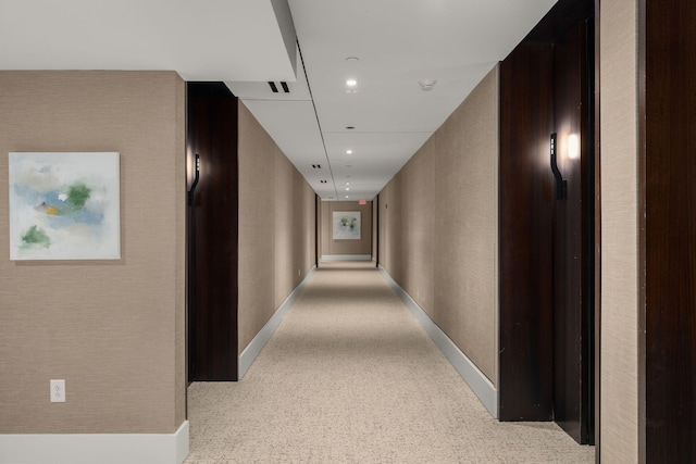 hall with a textured wall, recessed lighting, carpet flooring, and baseboards