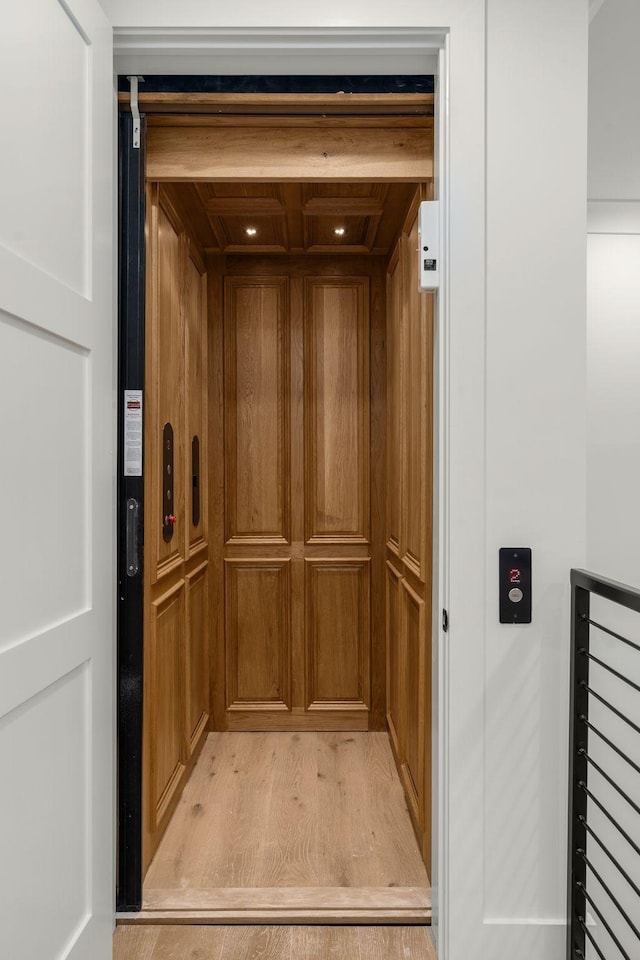 details featuring elevator and wood finished floors