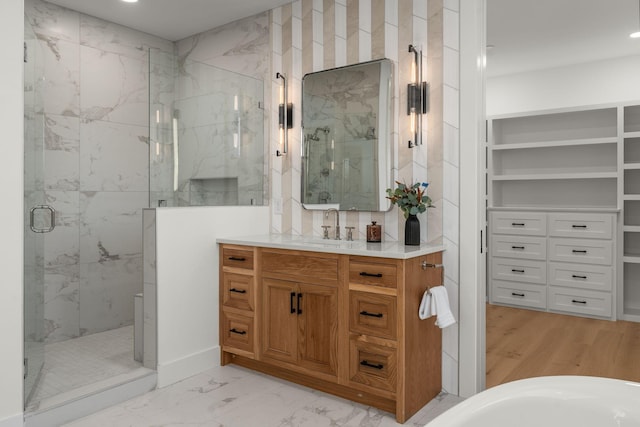 bathroom featuring recessed lighting, a marble finish shower, marble finish floor, and vanity
